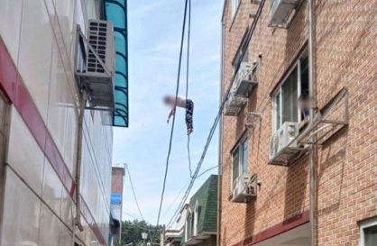 Woman dangling from power lines rescued by residents holding blanket