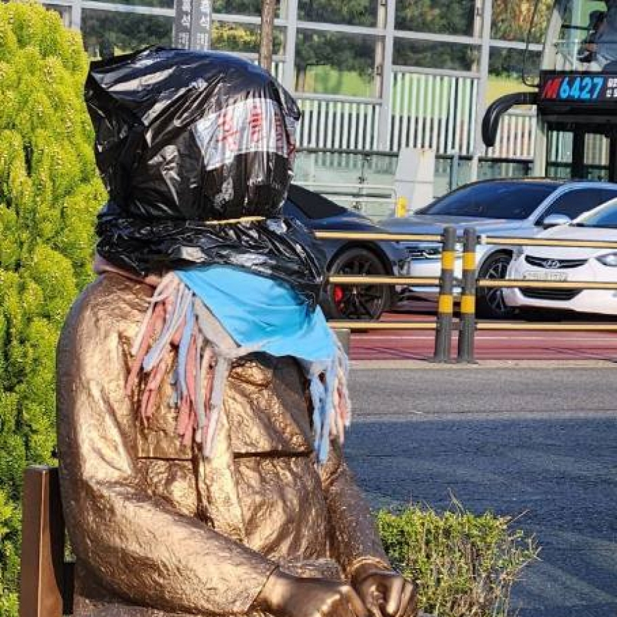 Man puts plastic bag over face of comfort women statue