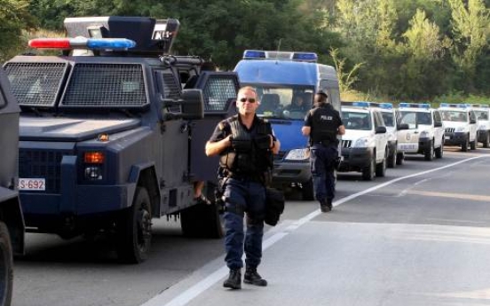 Kosovo police units wait near blockades set up by Kosovo Serbs on the Leposavic-Mitrovica road on Tuesday. AFP-Yonhap News