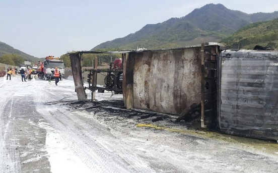 Cargo truck carrying paint overturns on highway, 2 injured