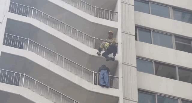 Firefighter saves woman hanging from high-rise balcony