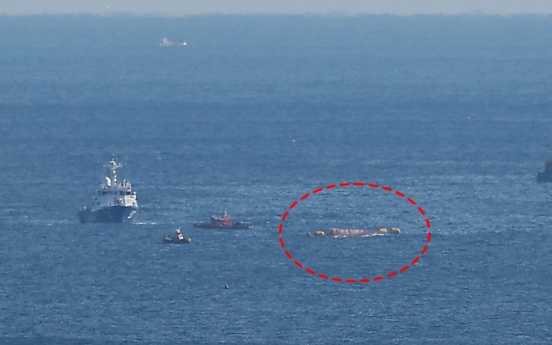 Capsized fishing boat plunges underwater while being towed