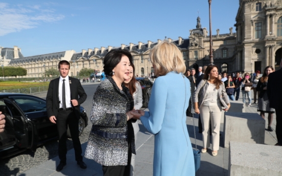 First ladies of South Korea and France walk arm in arm