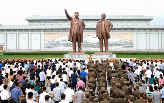 North Koreans pay tribute to Kim's father in freezing cold