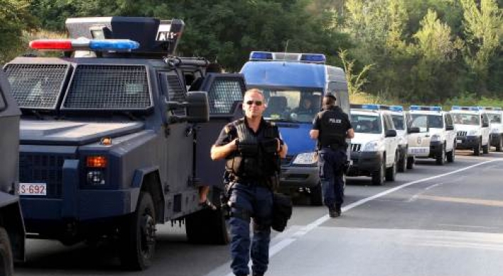 Kosovo police units wait near blockades set up by Kosovo Serbs on the Leposavic-Mitrovica road on Tuesday. AFP-Yonhap News
