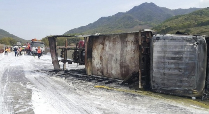 Cargo truck carrying paint overturns on highway, 2 injured