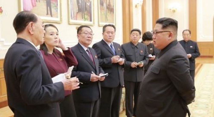 Who are nine NK officials accompanying Kim Jong-un?