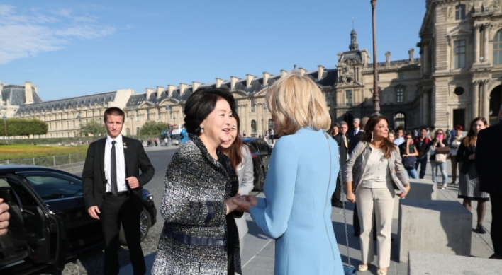 First ladies of South Korea and France walk arm in arm