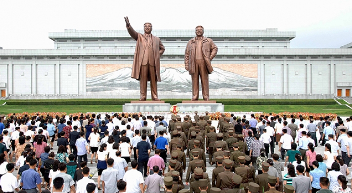 North Koreans pay tribute to Kim's father in freezing cold