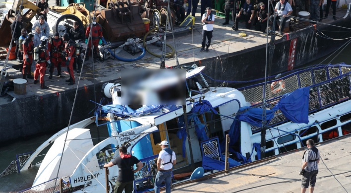 Sunken Hungary tour boat salvaged, placed on barge