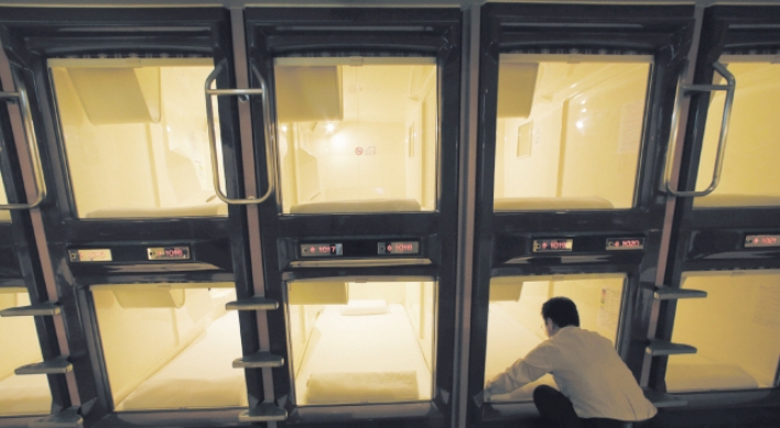 Squeezing into capsule hotel room in Japan