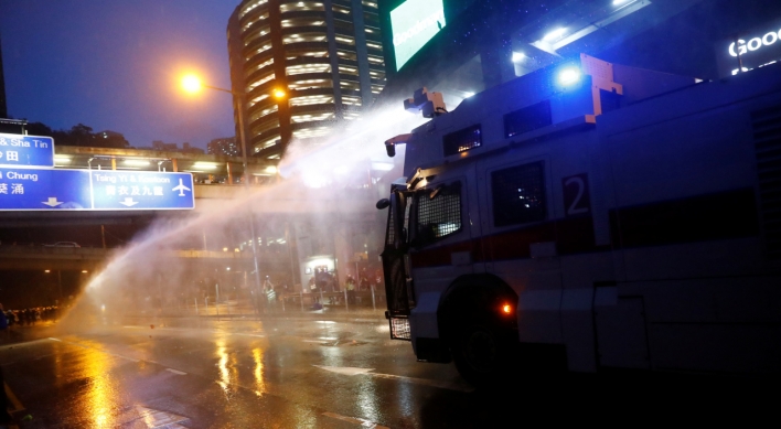 HK police say radical protesters forced use of water cannon, warning shot